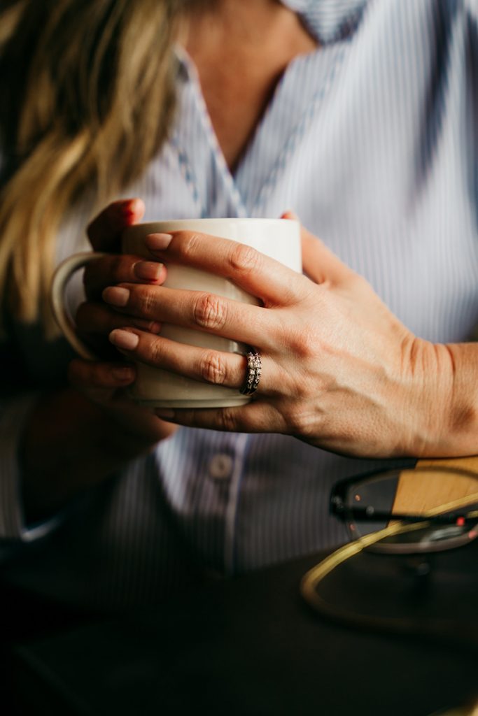 Wren's hands holding a coffee cup