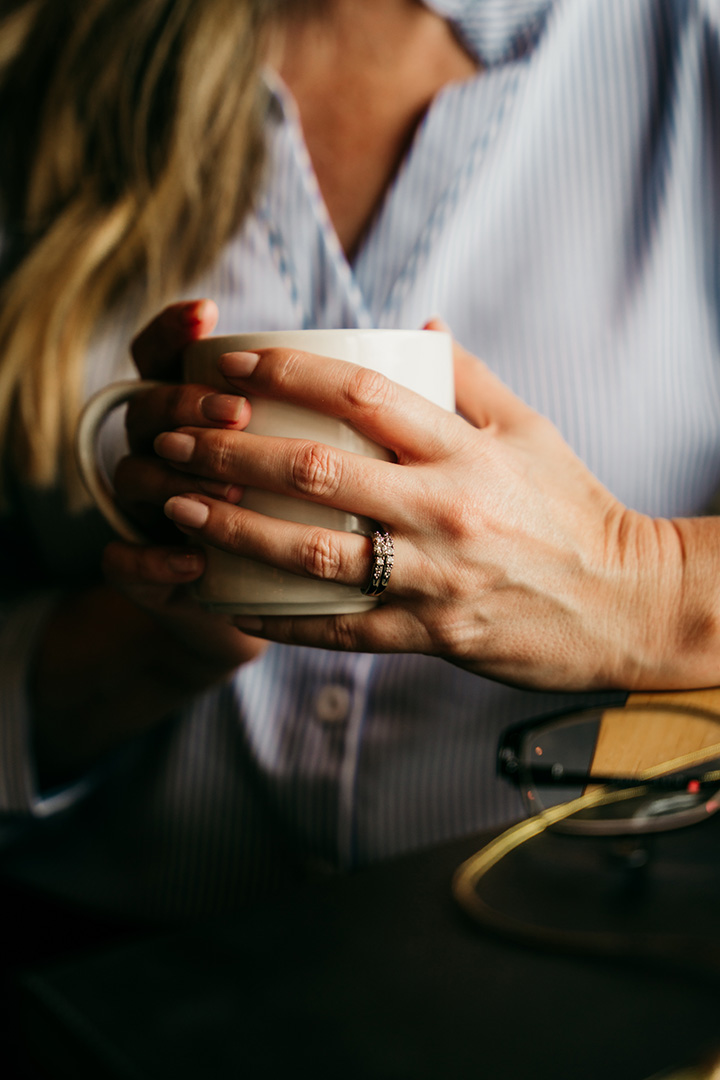 Wren's hands holding a coffee cup