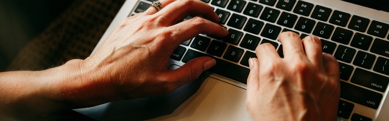hands on an apple laptop keyboard